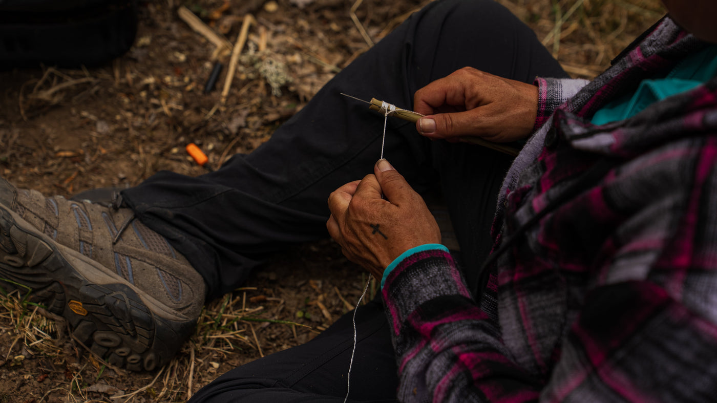 Close-up of a competitor wrapping cord around wood during a 2026 Survival Games skill task