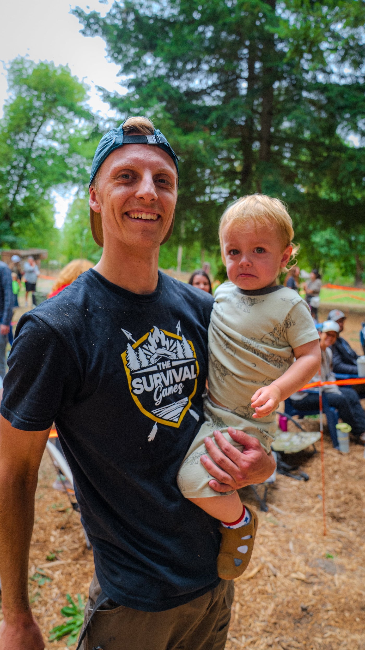 A smiling competitor holding a young child at the 2026 PNW Survival Games