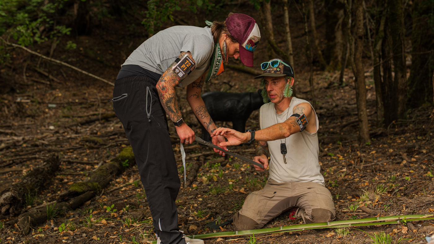 Two teammates working together on a woodland task during the 2026 Survival Games